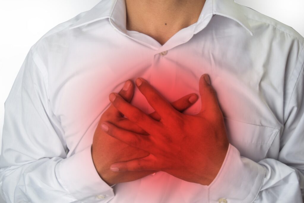 A person suffering from Acid Reflux grasping their chest and wondering how to treat Acid Reflux.