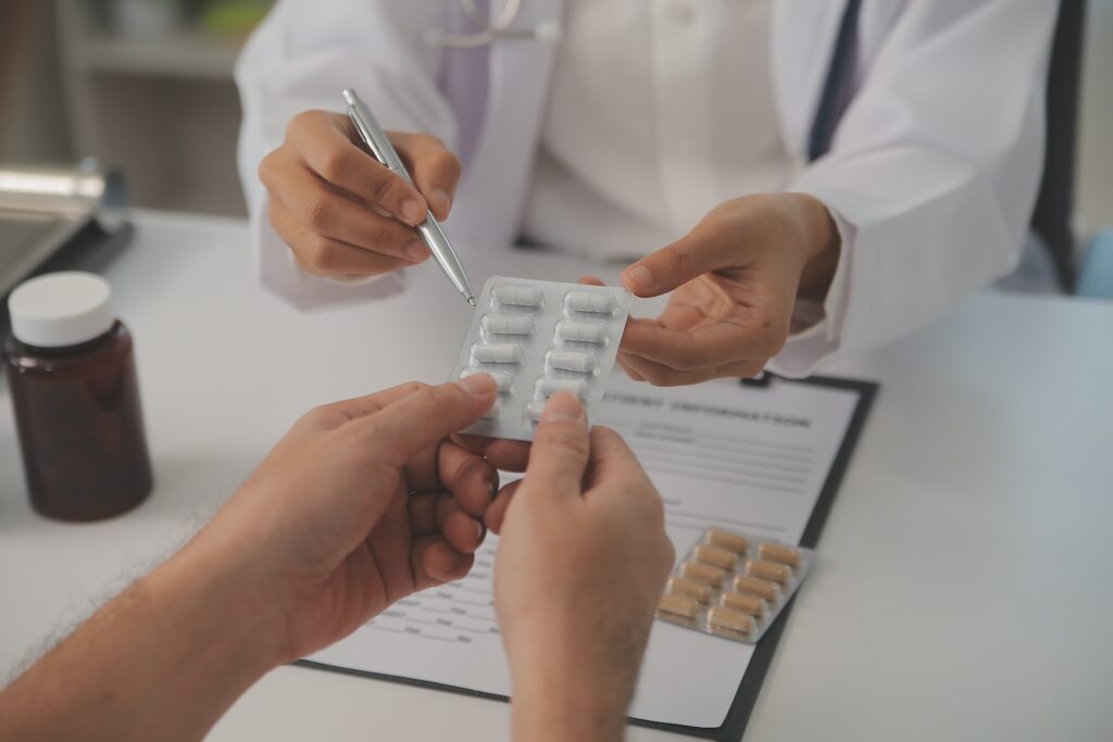 A Pharmacist Explaining To A Patient Whether They Can Get Antibiotics Over The Counter In The Uk Or Not