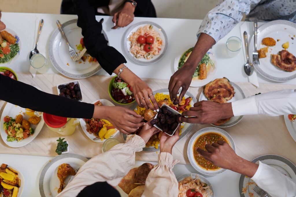 an image of people sitting round a table breaking fast during ramadan, discussing how to take mounjaro or wegovy during ramadan