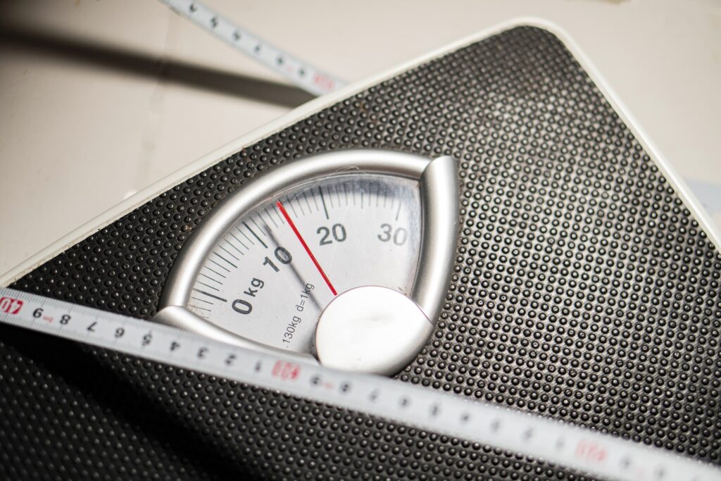 a scale and a tape measure representing who can take wegovy because of wegovy bmi requirements