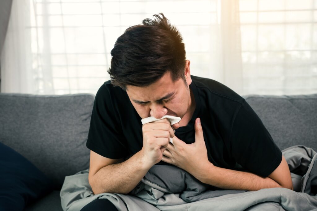 A man coughing, thinking about the best medicine for dry, tickly or chest coughs
