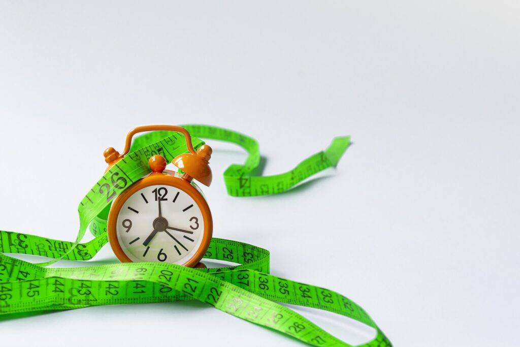 A clock with a measuring tape, to show How long can you stay on Mounjaro