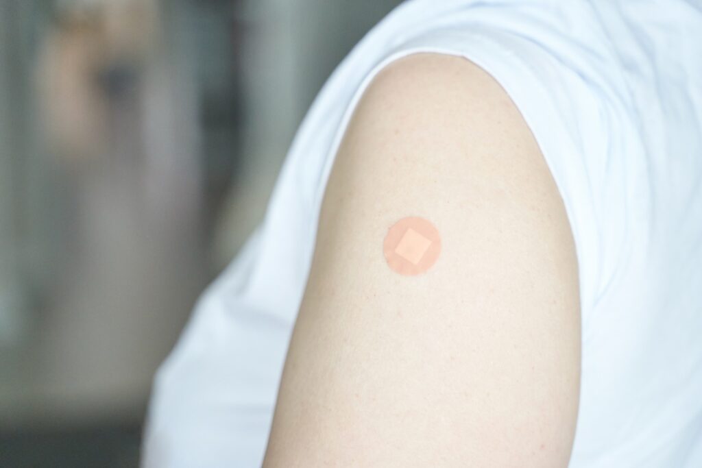 A close up of a plaster on a woman's arm, to express GLP-1 patches