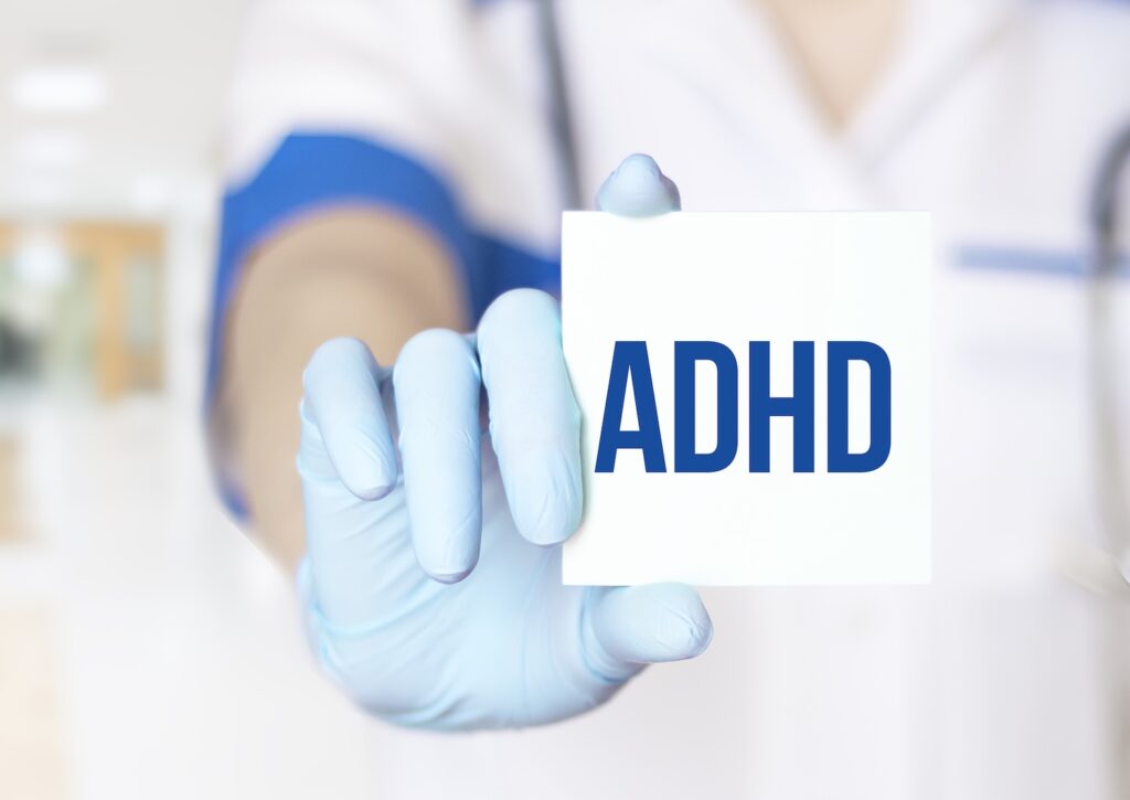 A pharmacist holding up a sign that says ADHD, to show how Mounjaro and ADHD interact