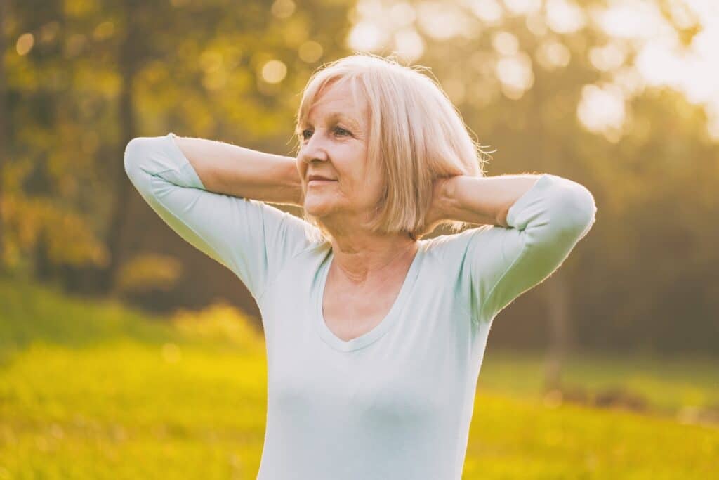 An older woman stood in a field aware of the alternatives to HRT